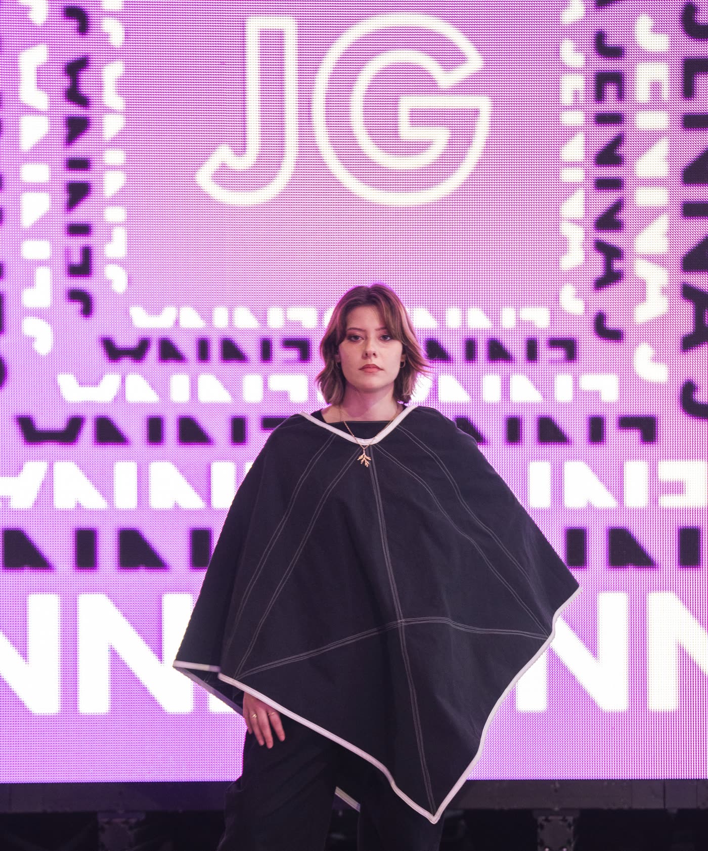 A model on the runway in front of the LED wall